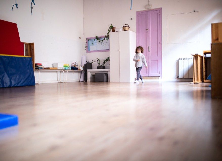 Sala de psicomotricidad, con suelo de madera y puerta lila