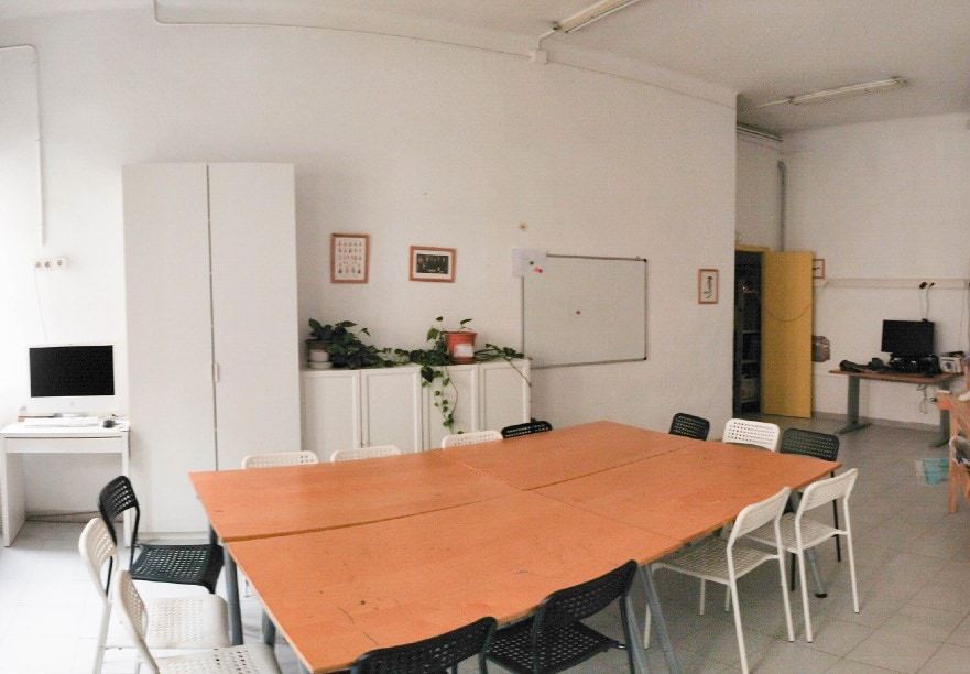 Sala amb una taula taronja i armaris blancs