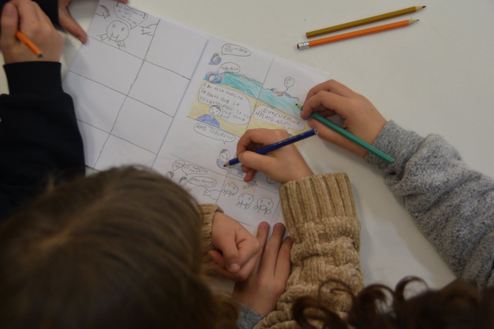 Two children drawing a comic strip together