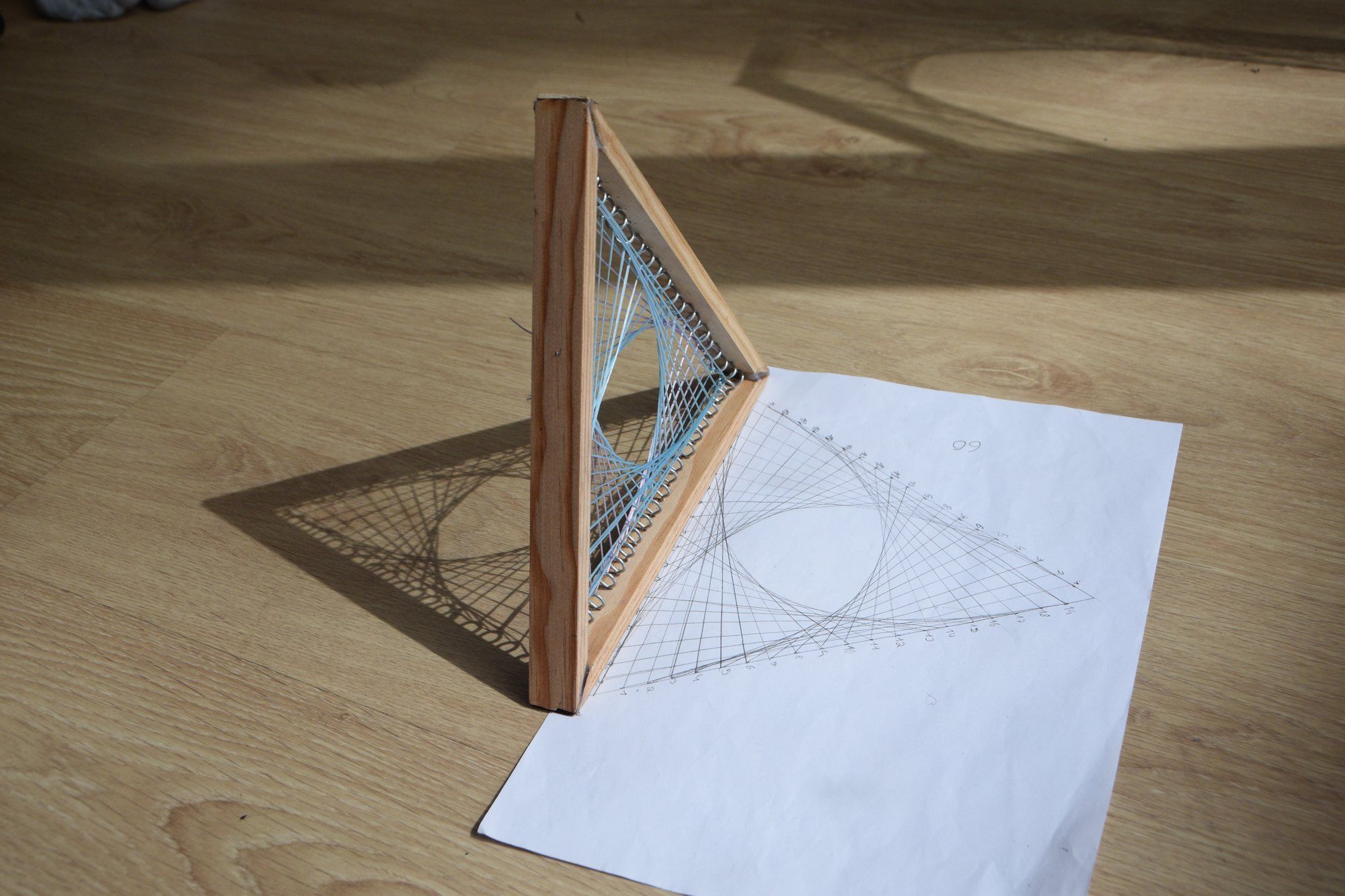 Projecte de geometria amb fils: corbes tensades sobre un marc de fusta