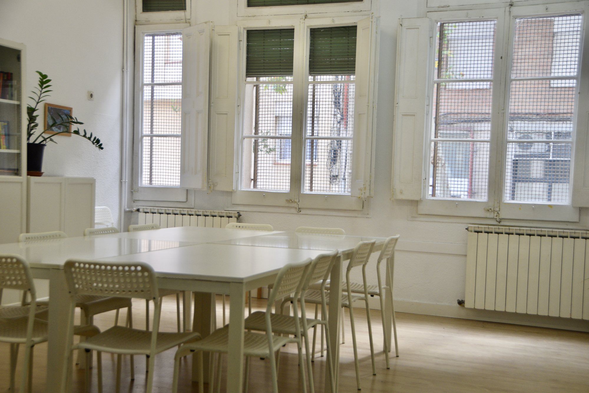 Primary room, with a white table, white chairs and bookshelves