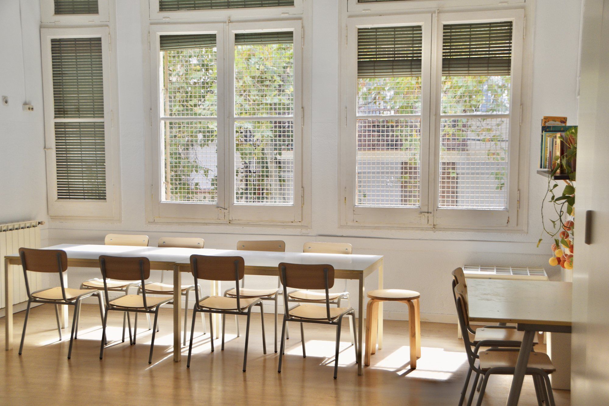 Lower primary room, with long tables, wooden chairs and large windows